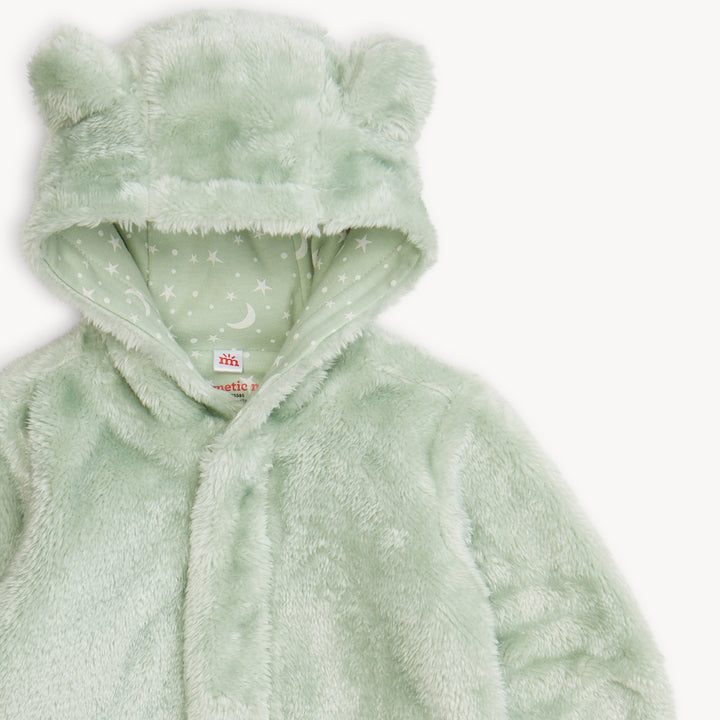 Green plush baby onesie with a hood on a white background